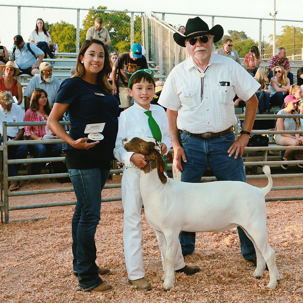 A boy with his prize winning goat at a fair